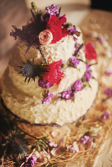 Rustic style weding cake with pops of bright pink and purple flowers - Photo by Ryan Flynn Photography